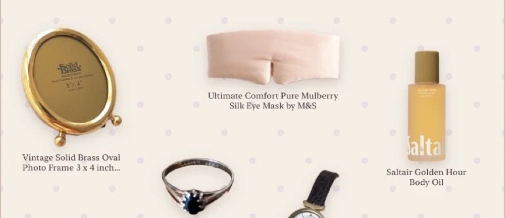 Close-up of an edit: a brass photo frame, silk eye mask, body oil, a sapphire ring and a vintage watch on a polka dot page